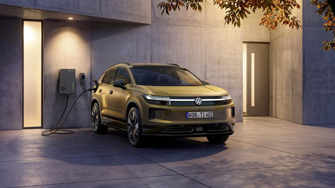 Elektrický Volkswagen ID. Tiguan připojený k wallboxu před moderním domem