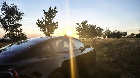 Tesla Model 3 Standard z bočního pohledu v letní krajině | zdroj: evmagazin.cz
