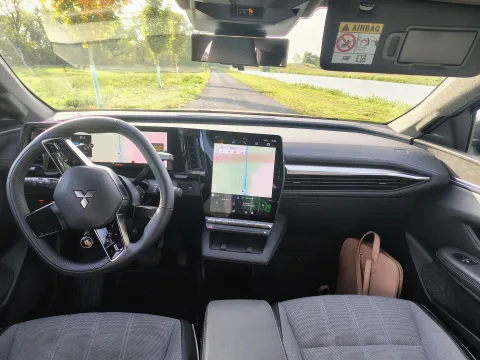 Mitsubishi Eclipse Cross EV — interiér, volant, displeje a přihrádka pro bezdrátové nabíjení telefonu