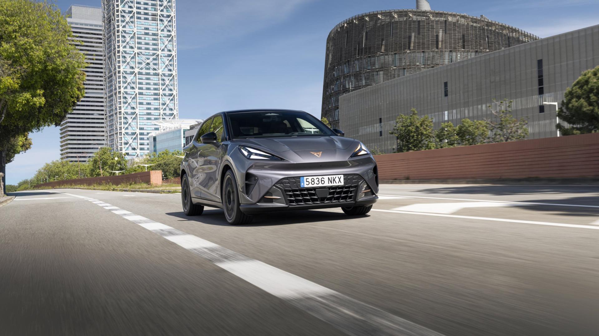 Šedá CUPRA Raval při jízdě po městské silnici, dynamický čelní tříčtvrteční pohled | zdroj: seat-cupra-mediacenter.com