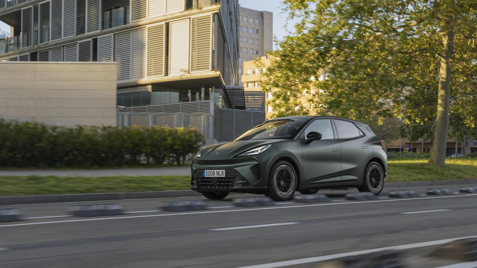CUPRA Raval v tmavě zelenošedém provedení při jízdě městskou ulicí, levý přední boční pohled | zdroj: seat-cupra-mediacenter.com