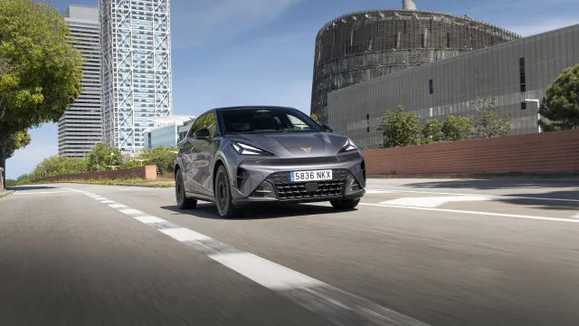 Šedá CUPRA Raval při jízdě po městské silnici, dynamický čelní tříčtvrteční pohled | zdroj: seat-cupra-mediacenter.com